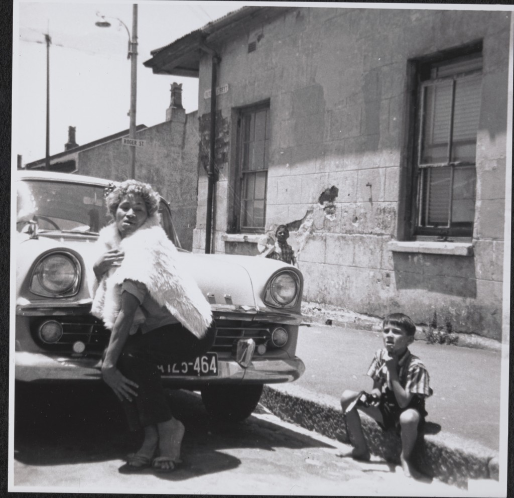 Samantha ‘with a floor mat over her as a cape’ in Rutgers Street. Neighbour’s child, Yusuf (Aysa’s son), is watching. Source: Kewpie collection, GALA archive.